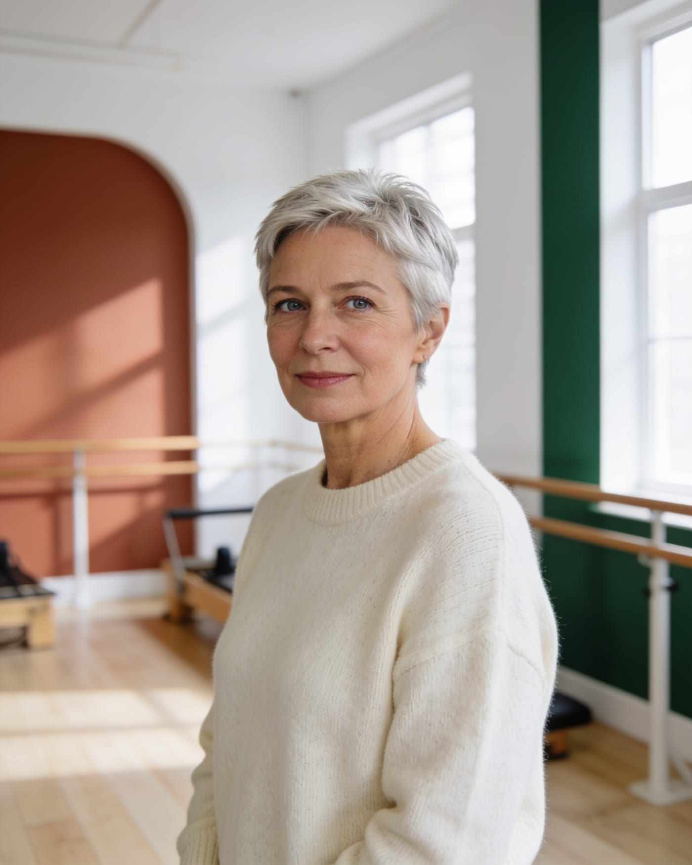 Grace, with short silver hair and a cream sweater, in the studio.